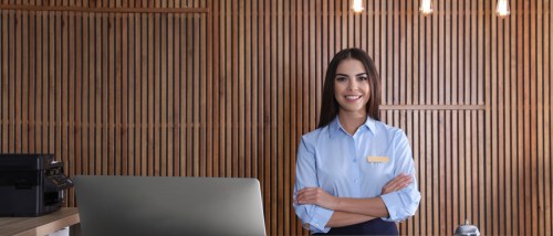 Young woman smiling behind the concierge desk at an apartment building.