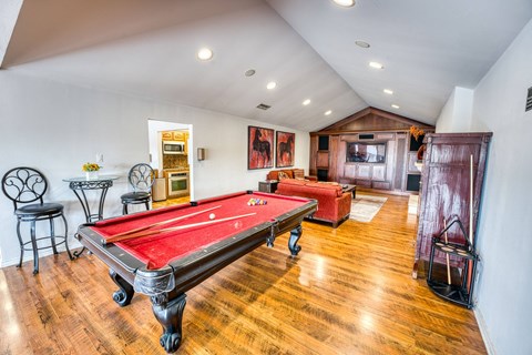 a game room with a red pool table and a red couch